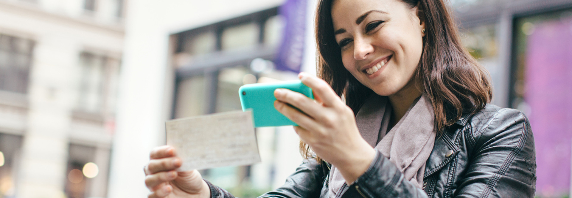 Young woman scanning a check with her smartphone camera