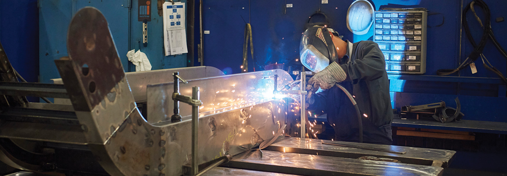 Man working with a blowtorch in an industrial setting 