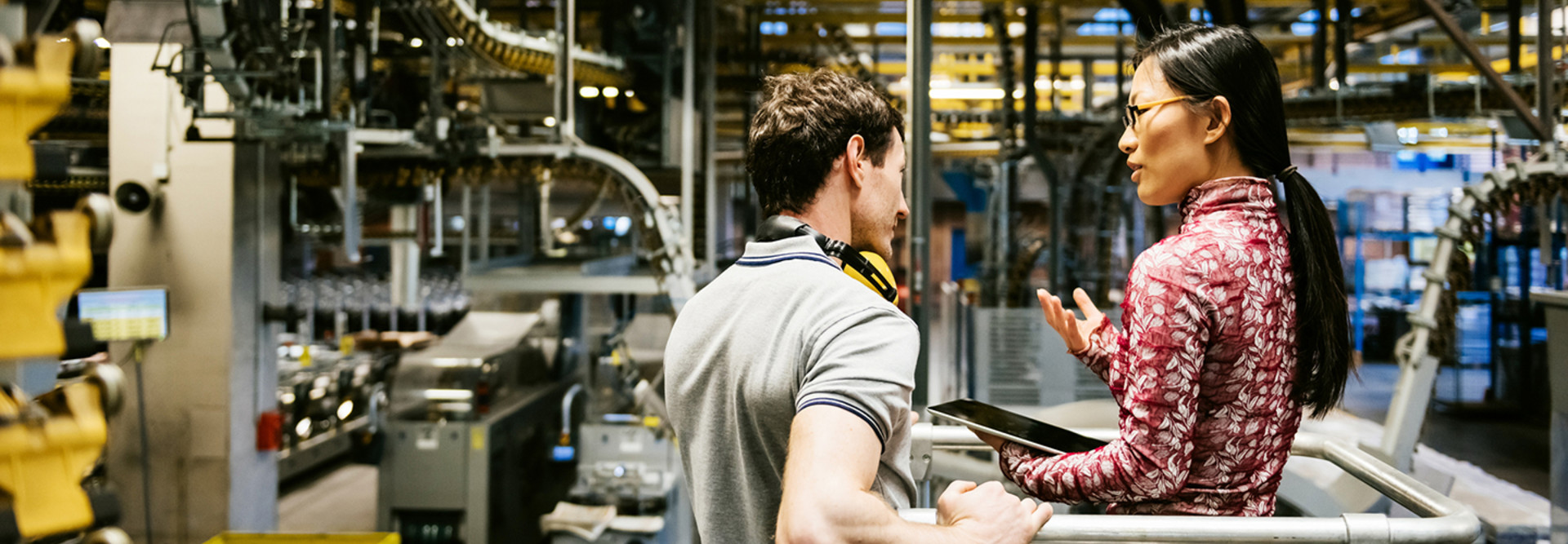 Male and female engineer using technology in a manufacturing plant 