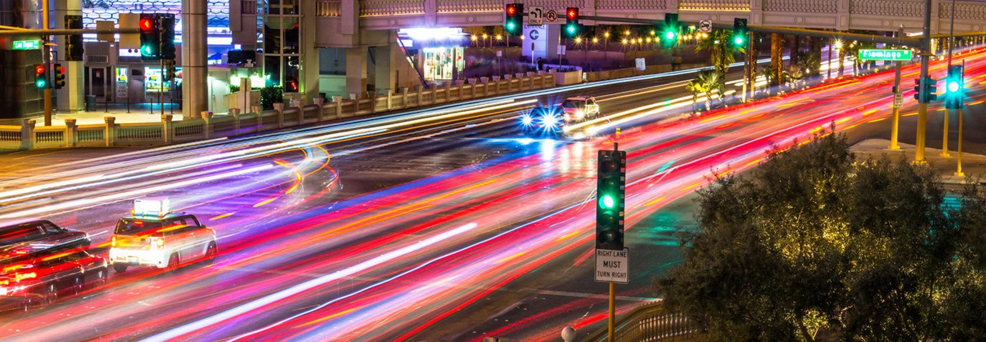 Photo taken above Las Vegas Boulevard (the strip), at night. Many car's light at blurred motion