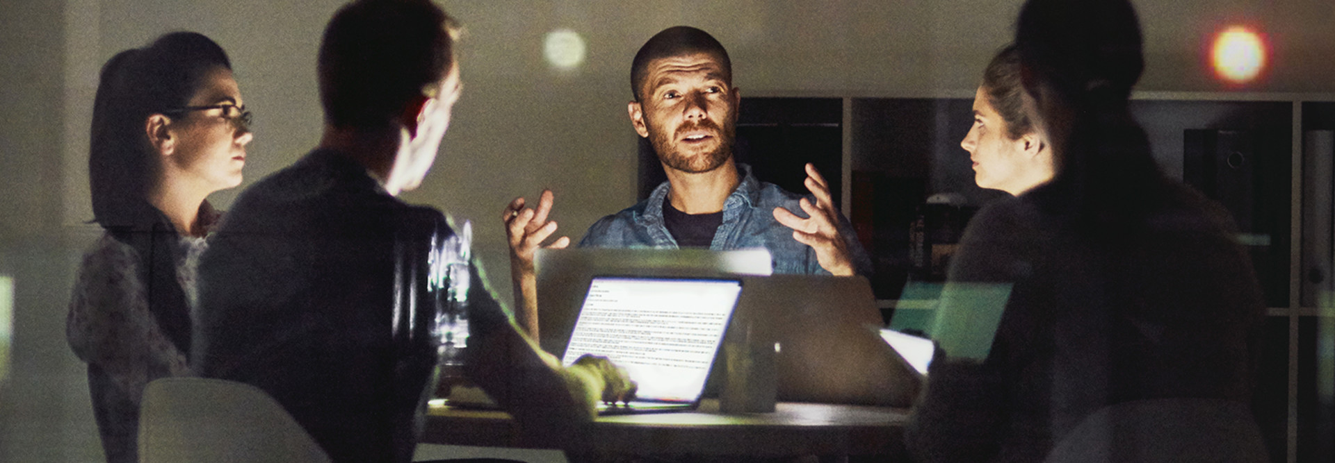 A group of men and women working late at night on a digital transformation project