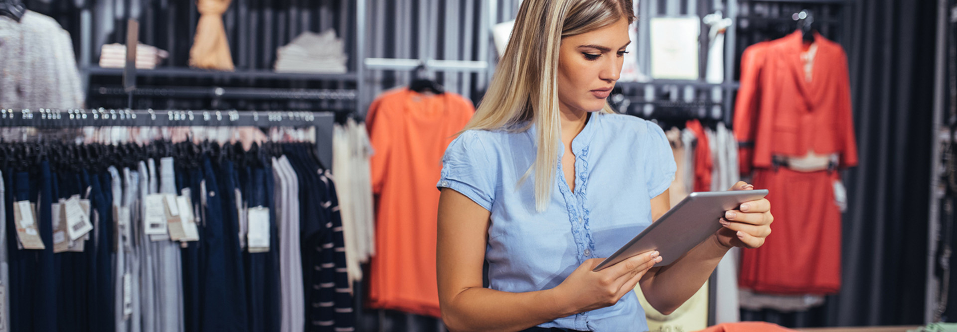 Woman retail worker using a tablet in a clothing store