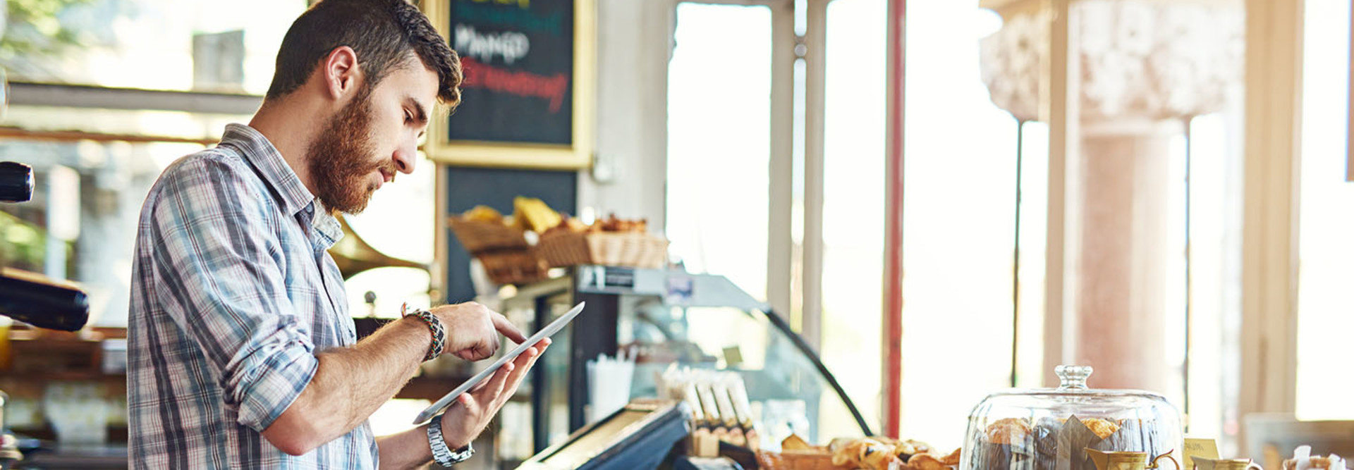 Shot of a young man using a digital tablet while working in a coffee shop