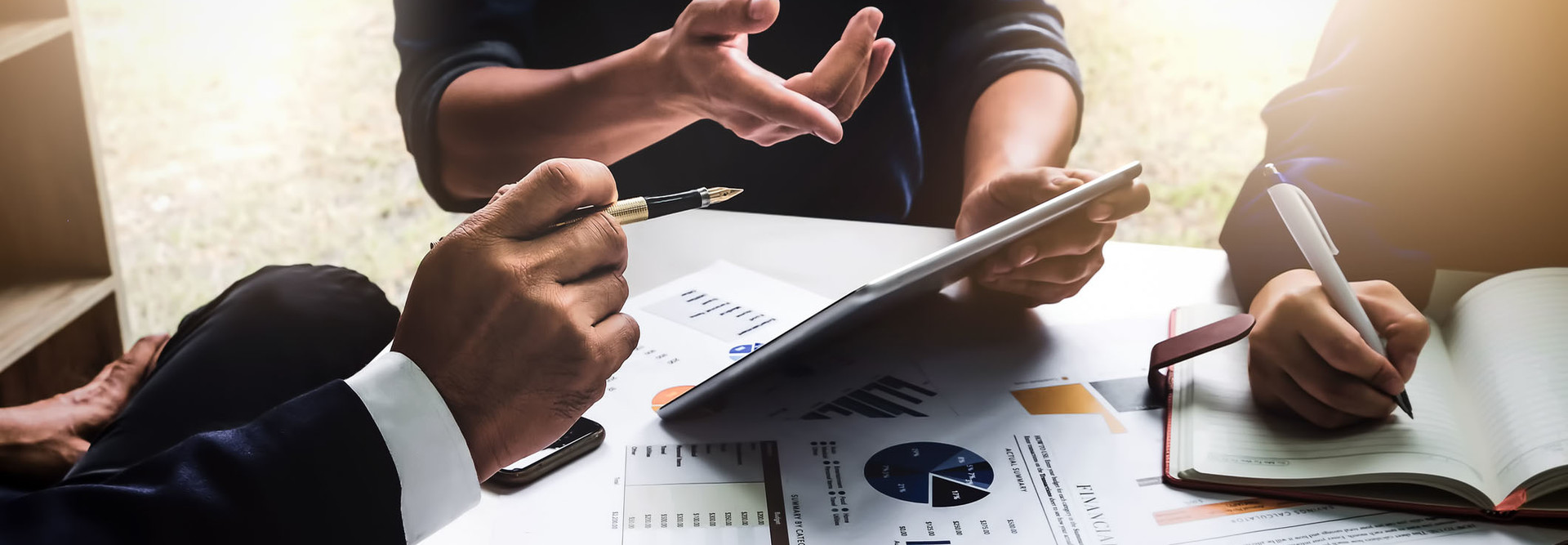 Business people using pen,tablet,notebook are planning a marketing plan to improve the quality of their sales in the future.