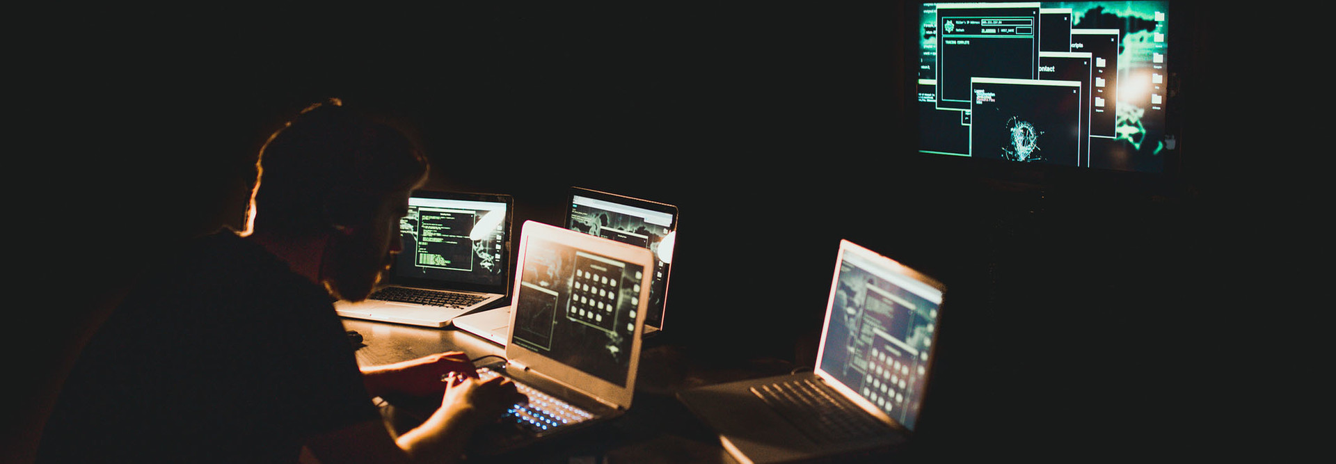 Hacker working on laptop late at night