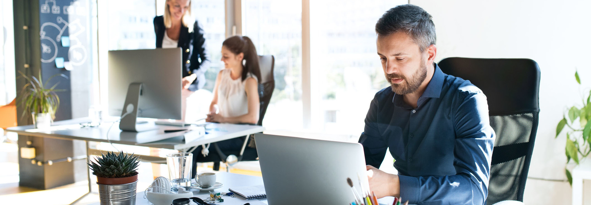 Three business people in the office working together.