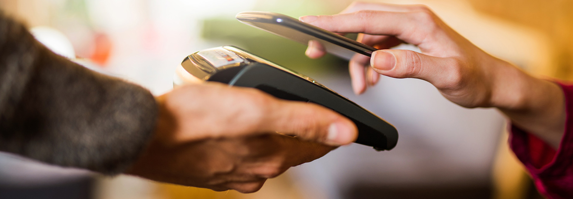 A store associate uses a mobile point-of-sale solution to accept contactless payment from a shopper