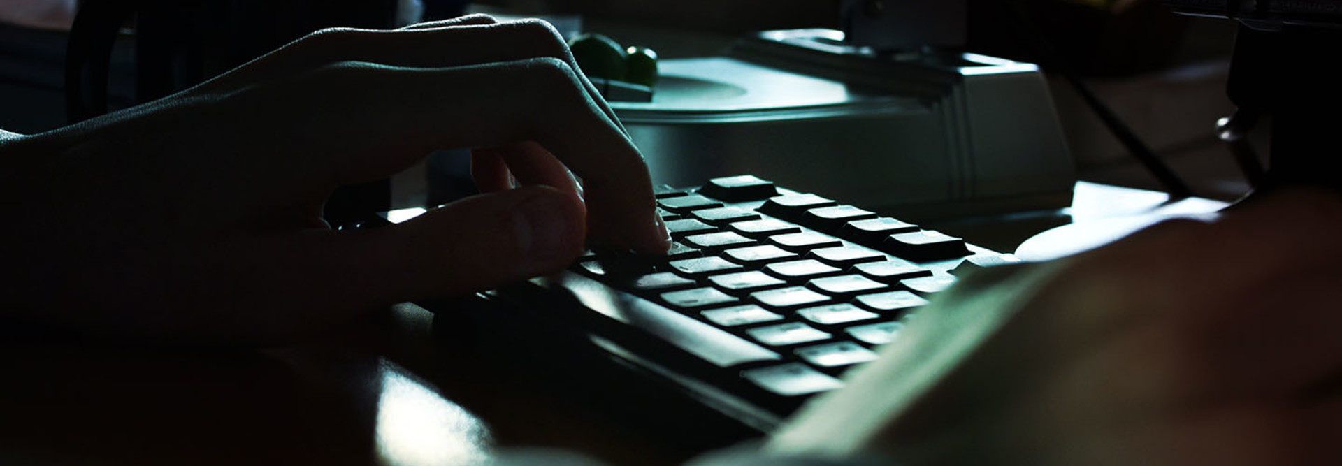 hands on the keyboard near smartphone on the desk