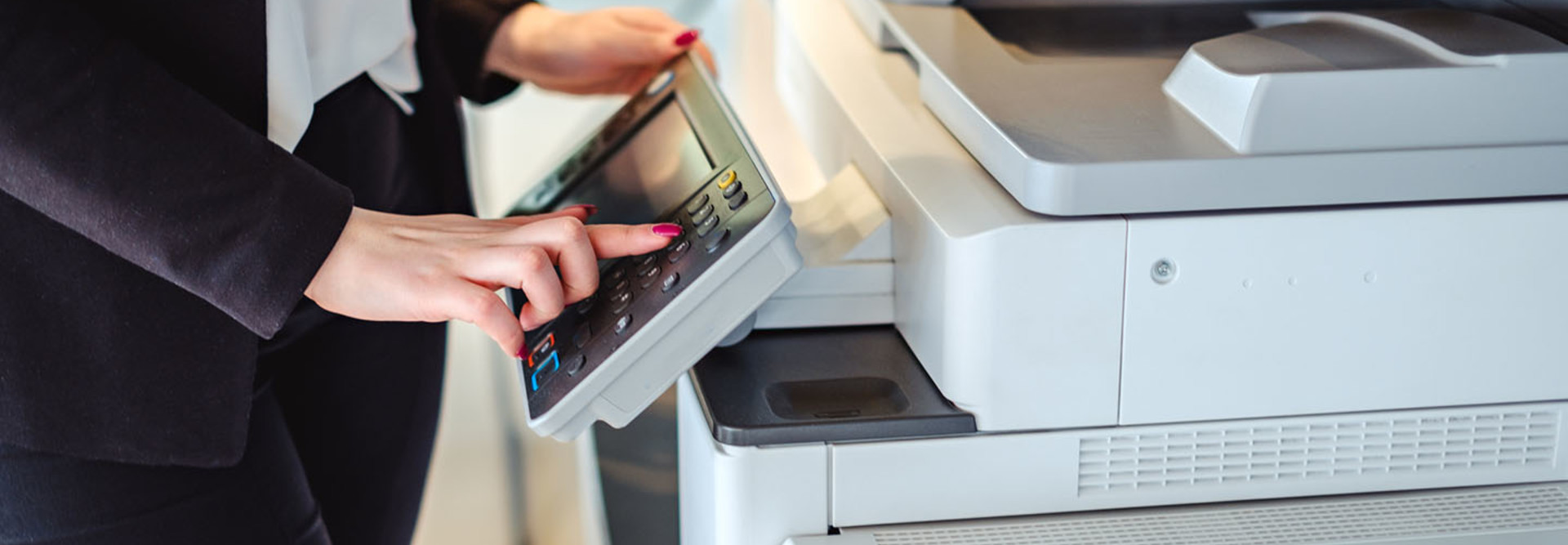 Woman pressing button on a copy machine in the office