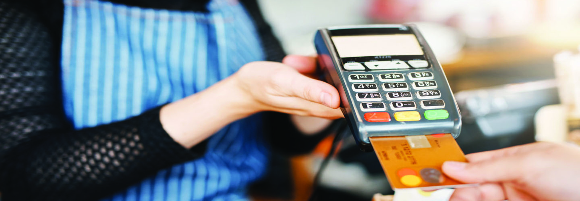 person inserting a credit card into a POS terminal