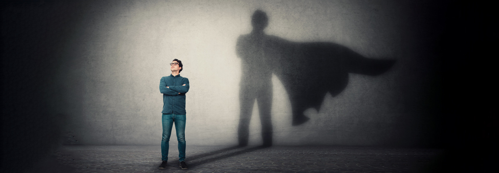 Person standing in front of superhero shadow