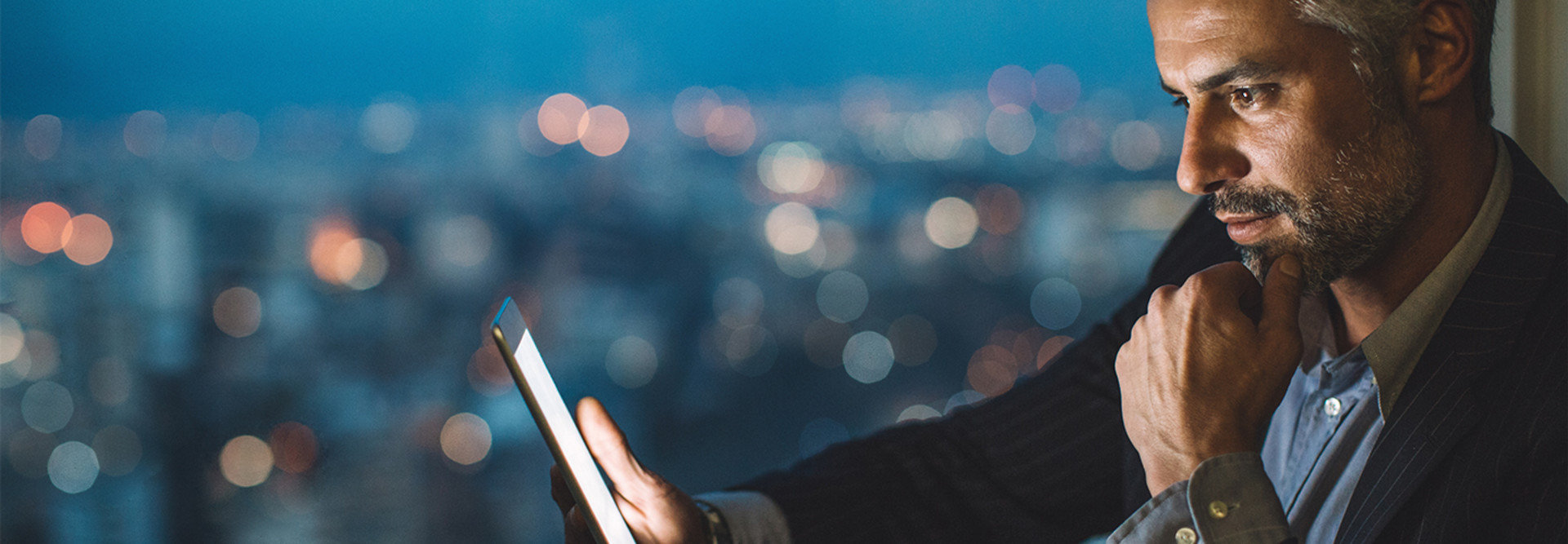 Man on ipad with city behind