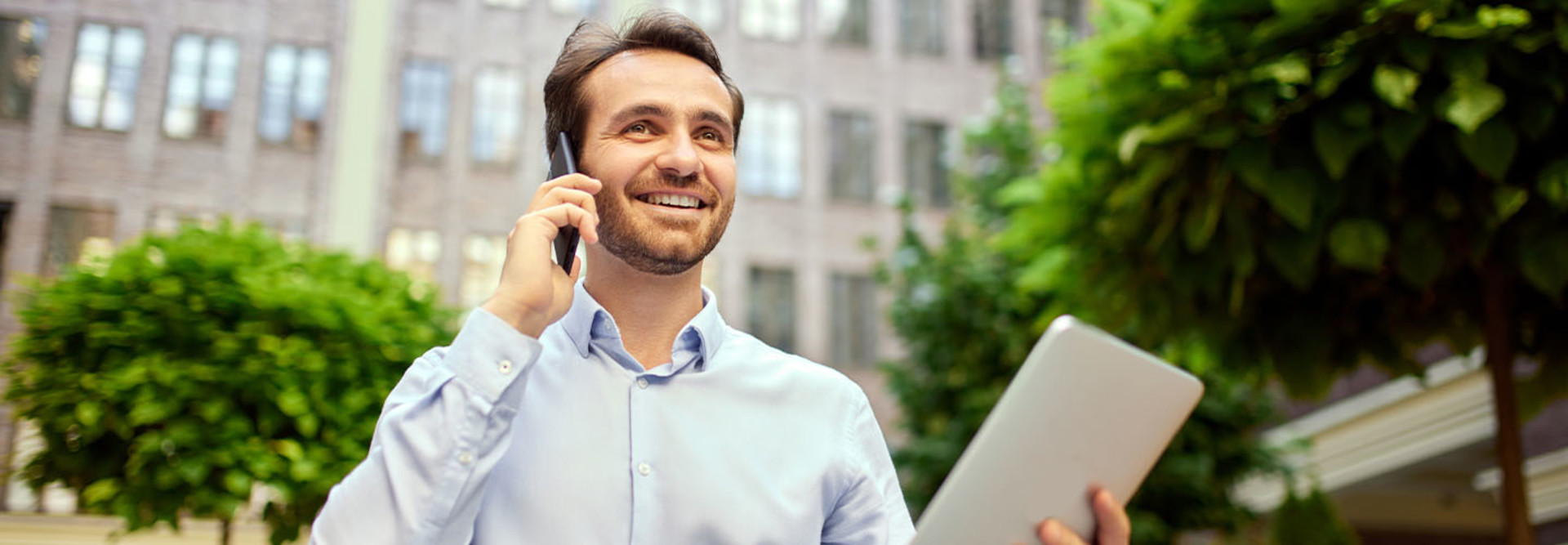 Person working outside on tablet and phone