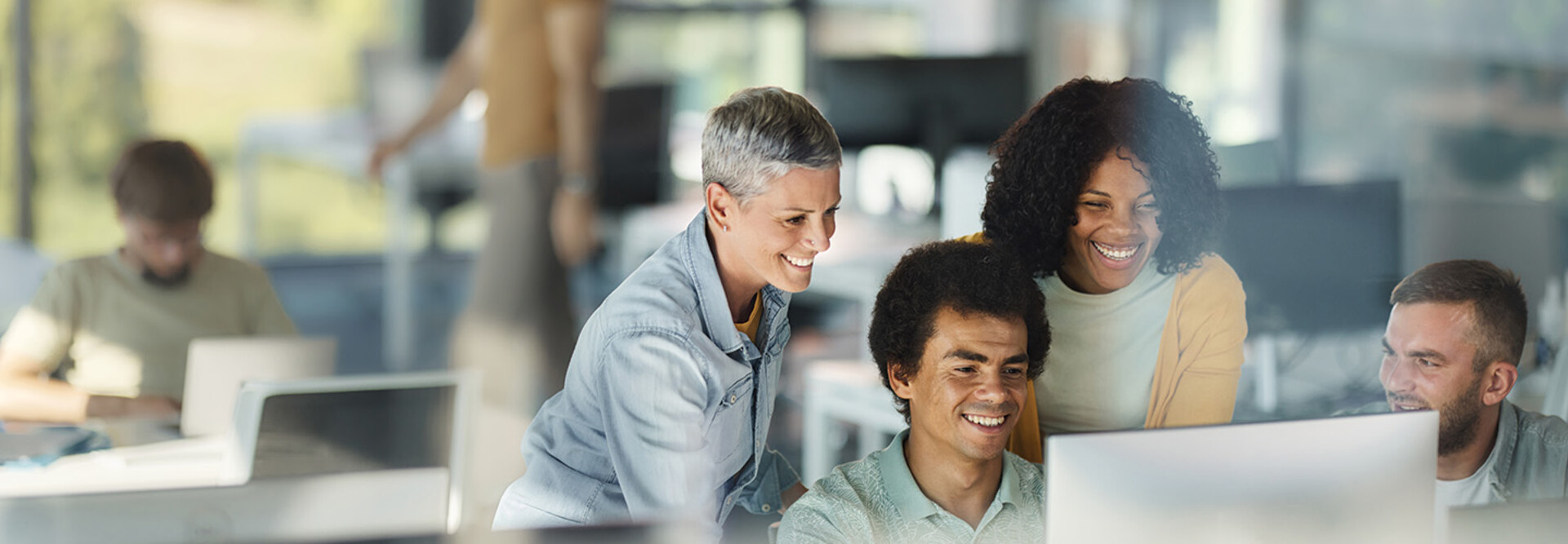 IT team smiles around computer