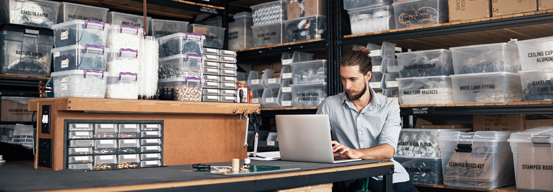small business owner does inventory on his laptop