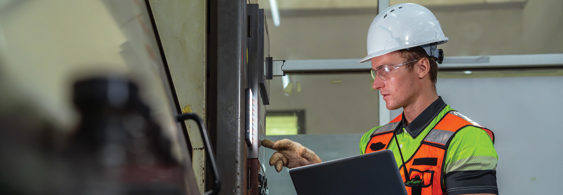 Worker checking a machine in a warehouse