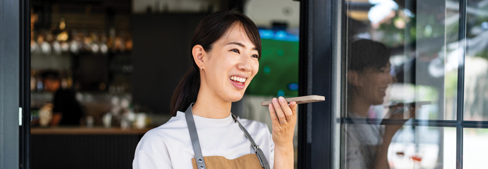 Woman uses phone voice command in cafe