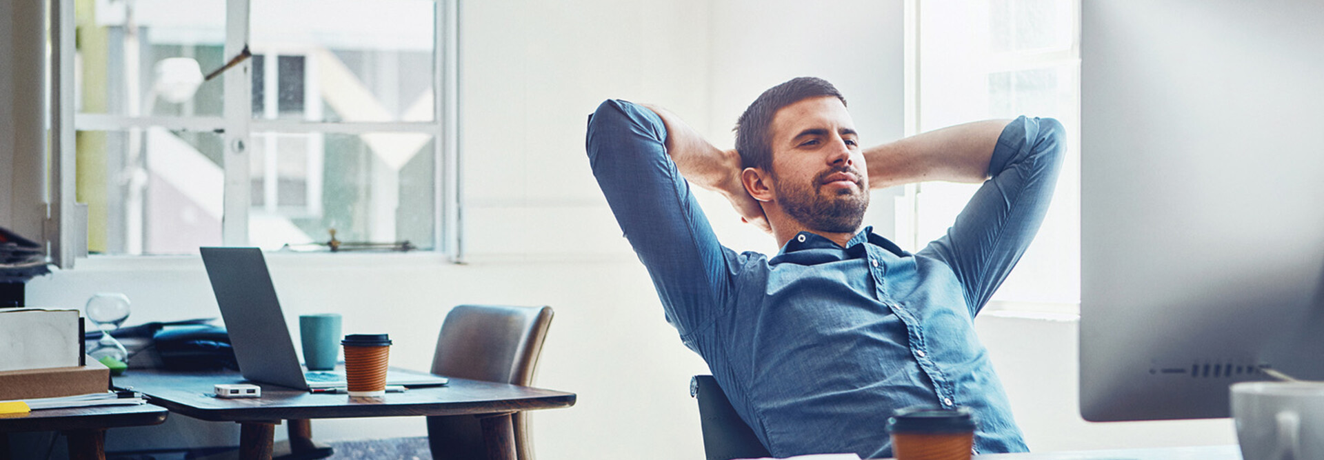 An employee leans back at his desk
