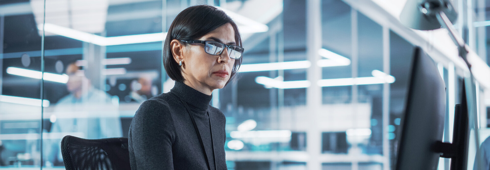 woman looks at computer monitor in office
