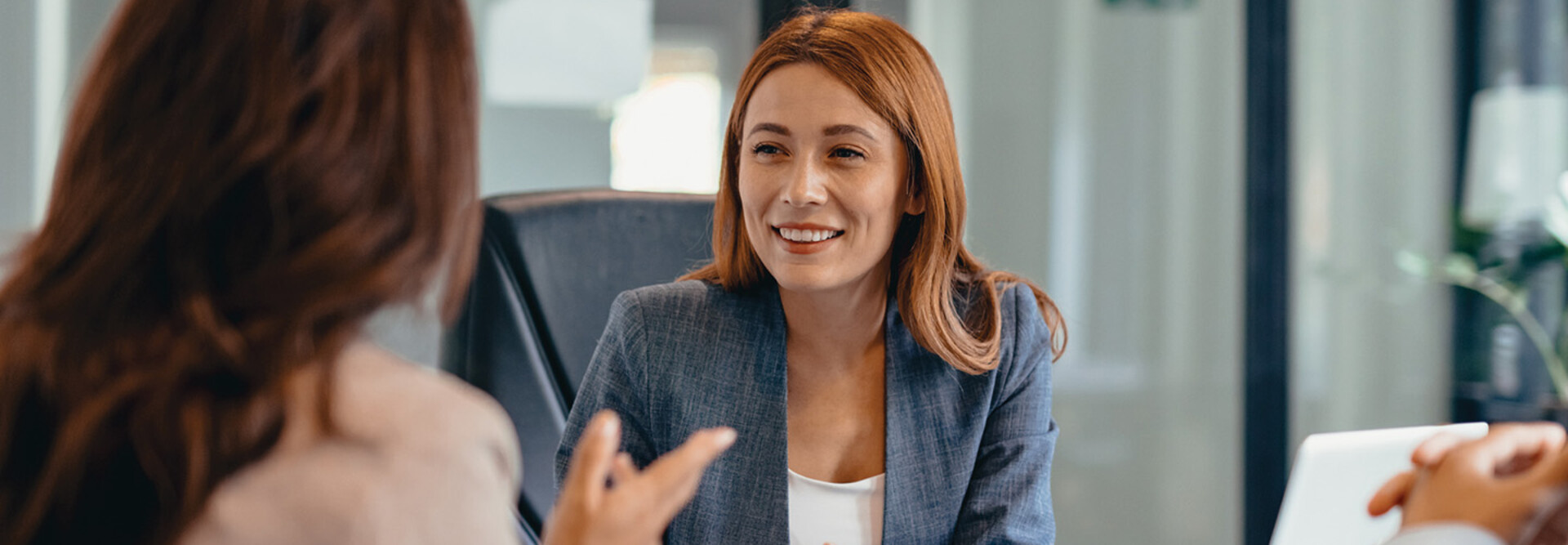 Three professionals in a discussion at an office meeting