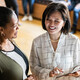 Two colleagues talking and using a digital tablet at work