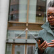 A woman on a smartphone in front of a sleek office building