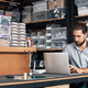 small business owner does inventory on his laptop