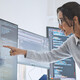 two people look at computer monitors