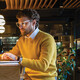 Businessman using laptop while sitting on seat at counter in cafe