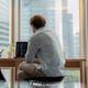 Adviser in modern office working on computer while speaking with clients