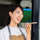 Woman uses phone voice command in cafe