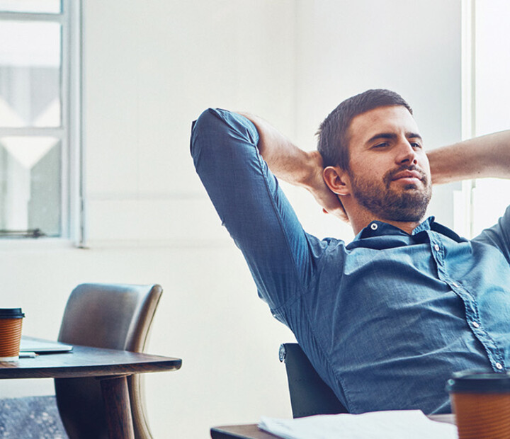 An employee leans back at his desk