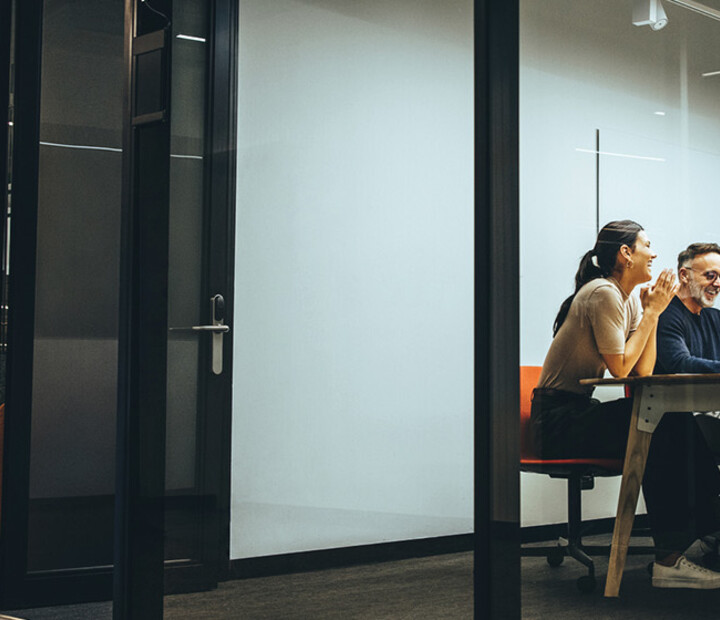 A group of employees gather in a meeting room