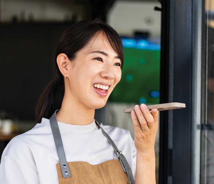 Woman uses phone voice command in cafe
