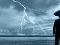 Man with umbrella and lightning on the horizon 