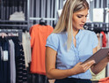 Woman retail worker using a tablet in a clothing store