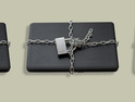 Closed laptop wrapped around with metal chain and locked with padlock