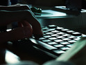 hands on the keyboard near smartphone on the desk