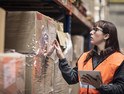 Woman doing inventory of boxes in a warehouse