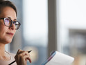 woman taking notes remotely