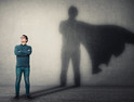 Person standing in front of superhero shadow