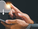 Innovative technology is at the businessman's fingertips as he touches the cloud icon.