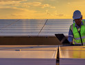 Engineer using laptop at solar panels