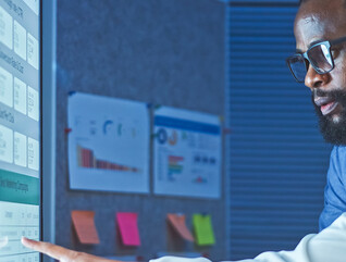 Co-workers reviewing data on a large screen