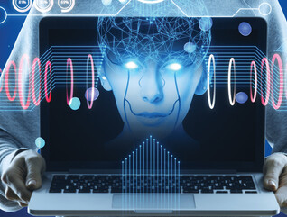 Hacker holding computer with floating face representing AI cyberattacks