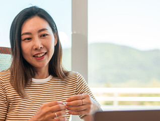 A woman works from home using AI and a laptop