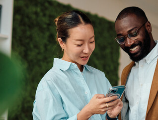 IT leaders holding an android phone in workspace
