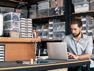 small business owner does inventory on his laptop