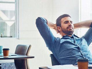 An employee leans back at his desk
