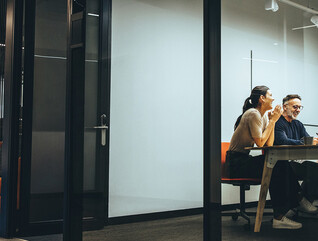A group of employees gather in a meeting room
